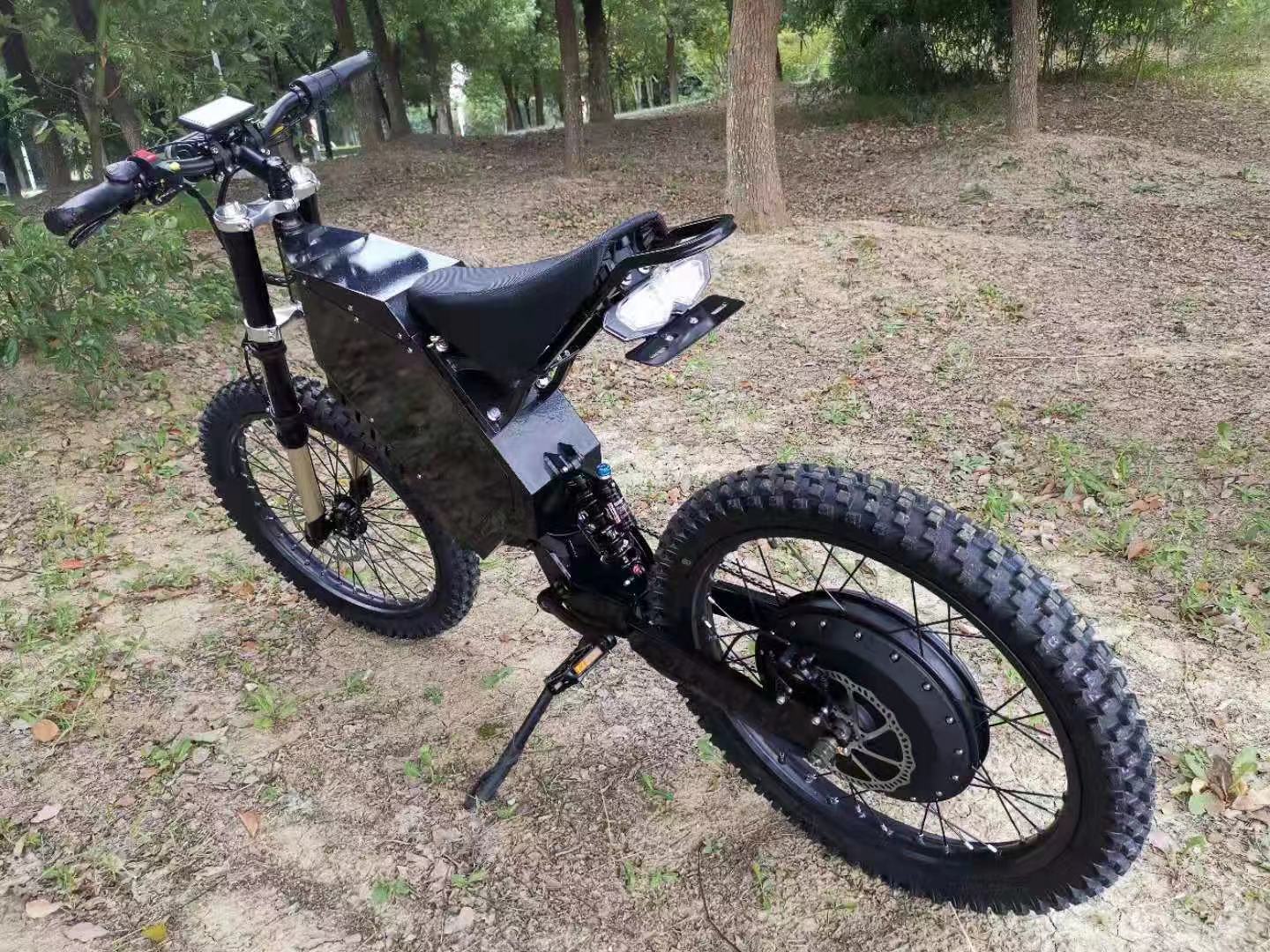 72v 3000w stealth bomber bike with motorcycle seat, black motorcycle wheel, frame, hydraulic disc brake on mountain trail
