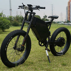 26x4.0 fat wheel stealth bomber ebike 3000w 72v with black frame, kke front fork, bicycle seat, headlight and hydraulic disc brake on grass