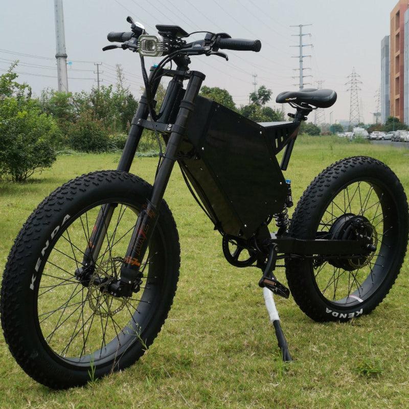 26x4.0 fat wheel stealth bomber ebike 3000w 72v with black frame, kke front fork, bicycle seat, headlight and hydraulic disc brake on grass