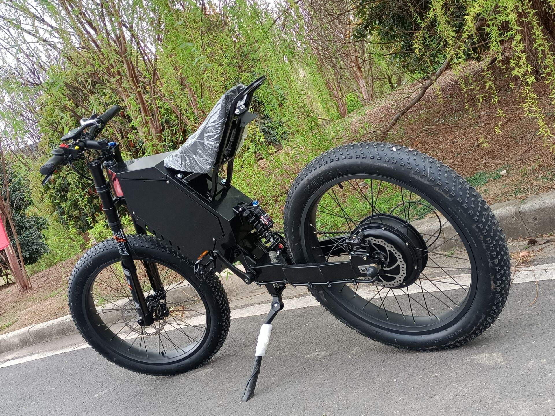 72v 3000w stealth bomber ebike with fat wheel, black frame, motorcycle seat, kke front fork on private road
